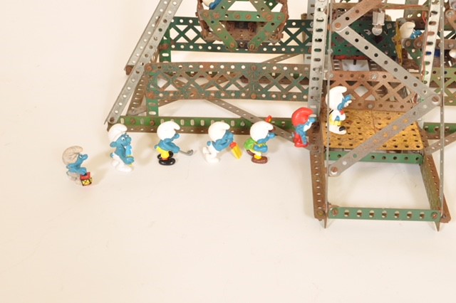 Photograph of Seven Smurf figurines in a line for a metal model ferris wheel